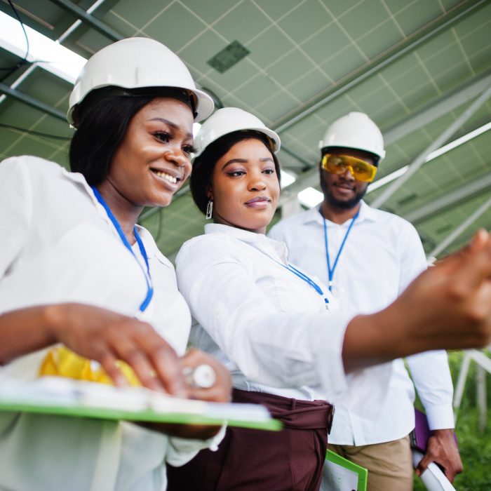 African american technician checks the maintenance of the solar panels. Group of three black engineers meeting at solar station. Make selfie by phone.
